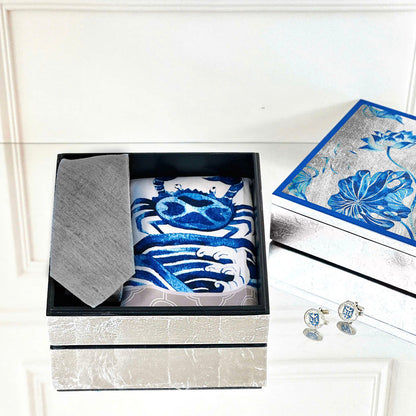 Set of blue and white patterned fabric items in a box with a matching box and cufflinks on a white surface.